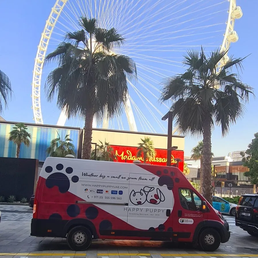 Happy Puppy grooming van parked at JBR with Ain Dubai in the background
